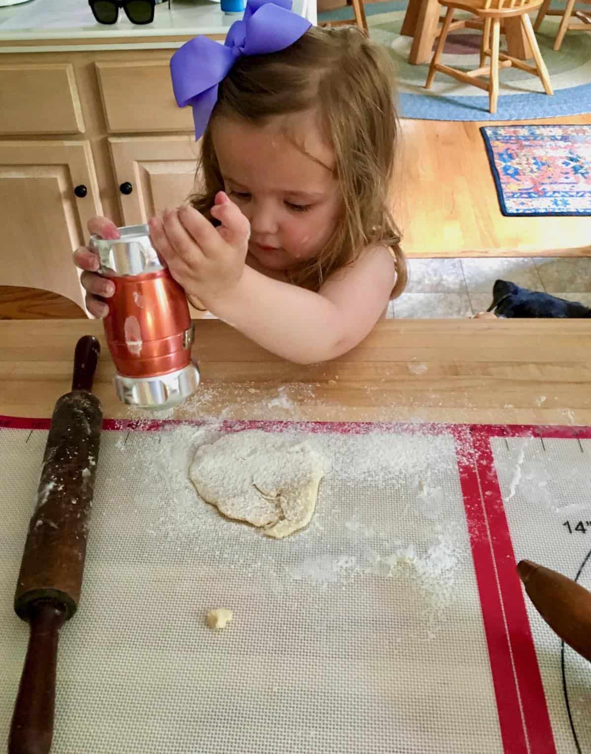 Grand daughter rolling pie dough.