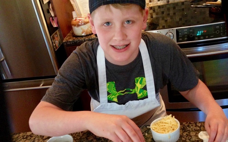 Aidan in the kitchen giving life celebration pizza.