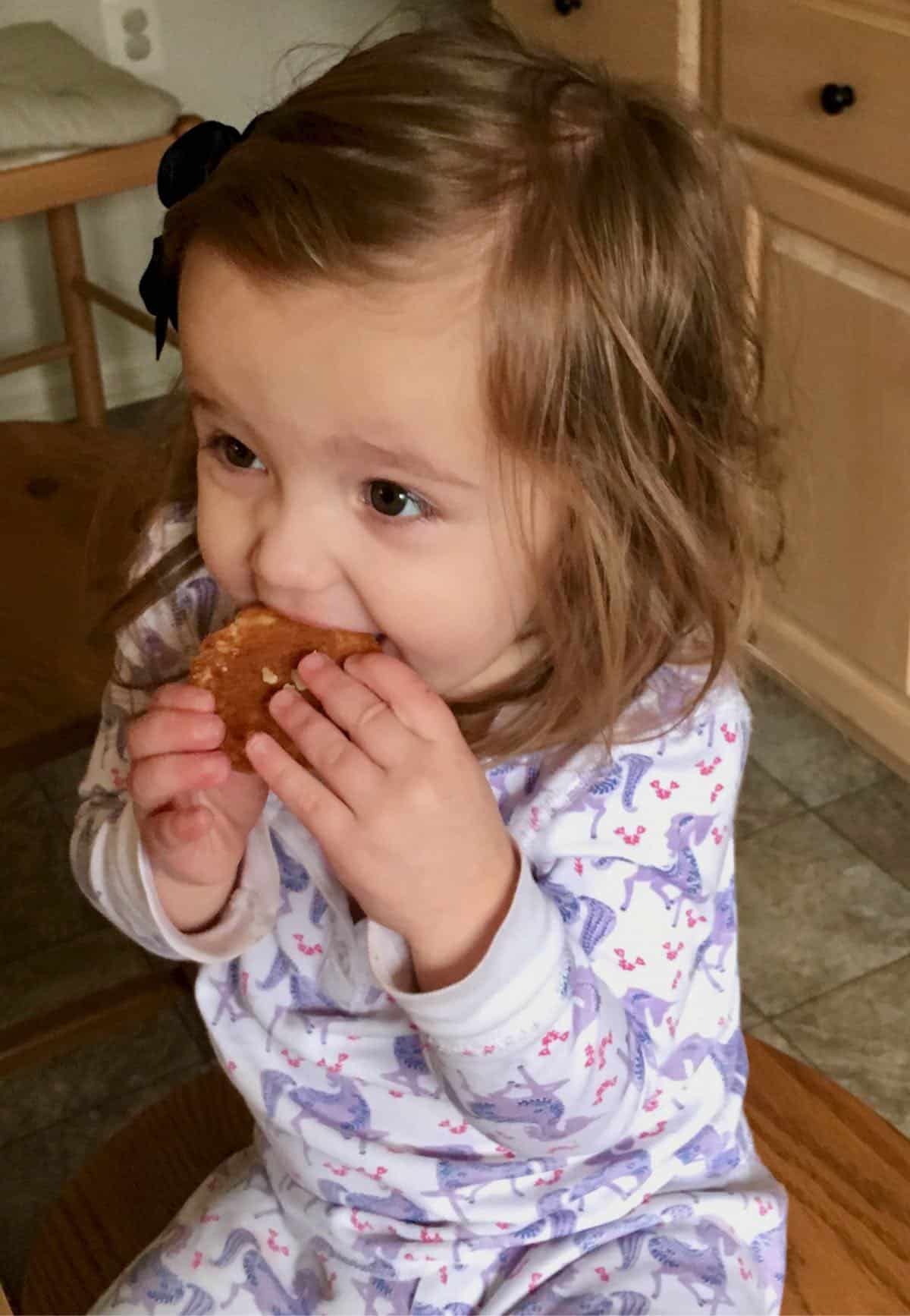 Grand daughter eating cookie.