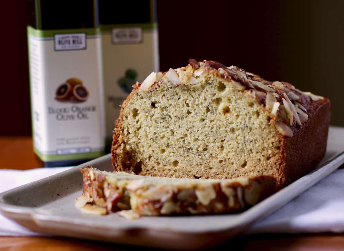 Sliced banana bread with olive oil bottles.