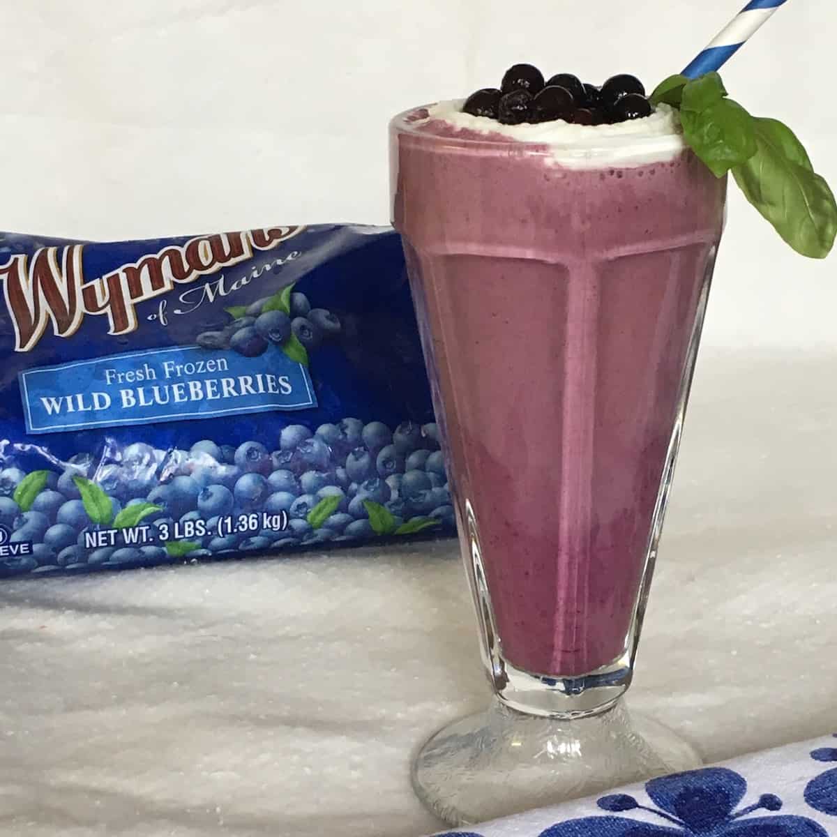 Wild blueberry smoothie with a straw and product package.