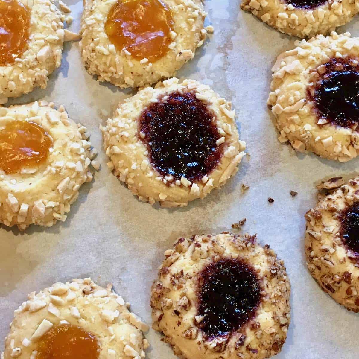Thumbprint jelly cookies on parchment paper.