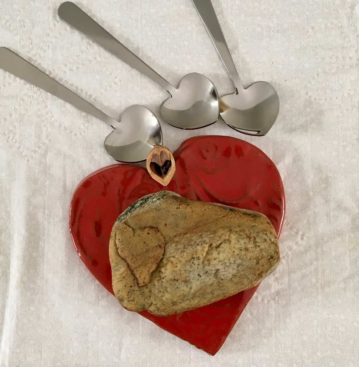 Heart shapes: rock, spoons and ceramic tile.