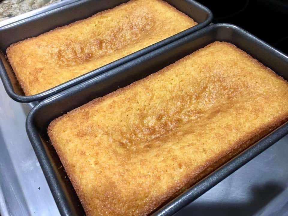 Sliced lemon loaf with white icing and lemon slice garnish.