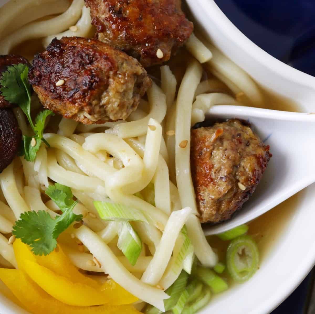 Bowl of Asian meatball noodle soup.