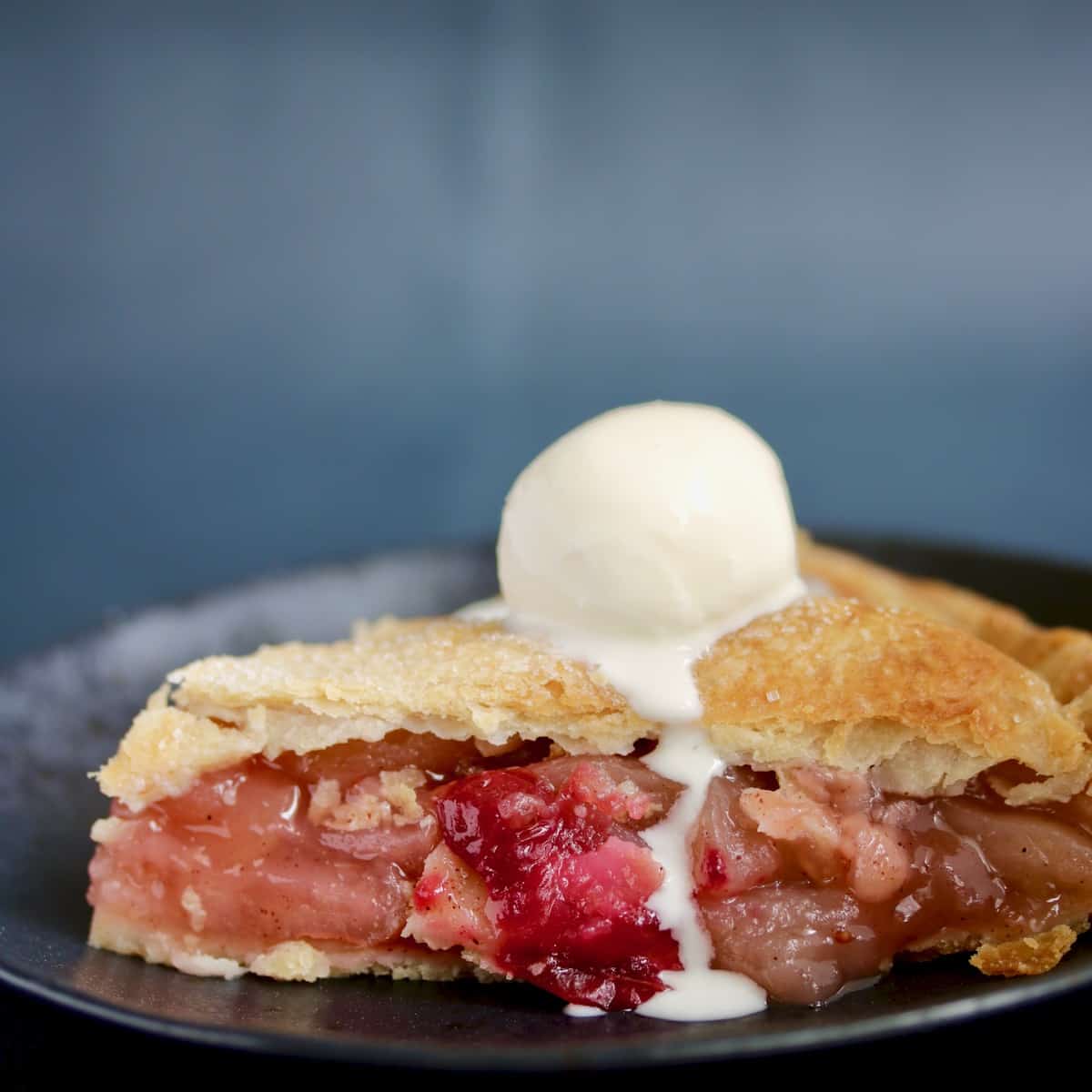 Slice of sous vide apple pie with melted ice cream.