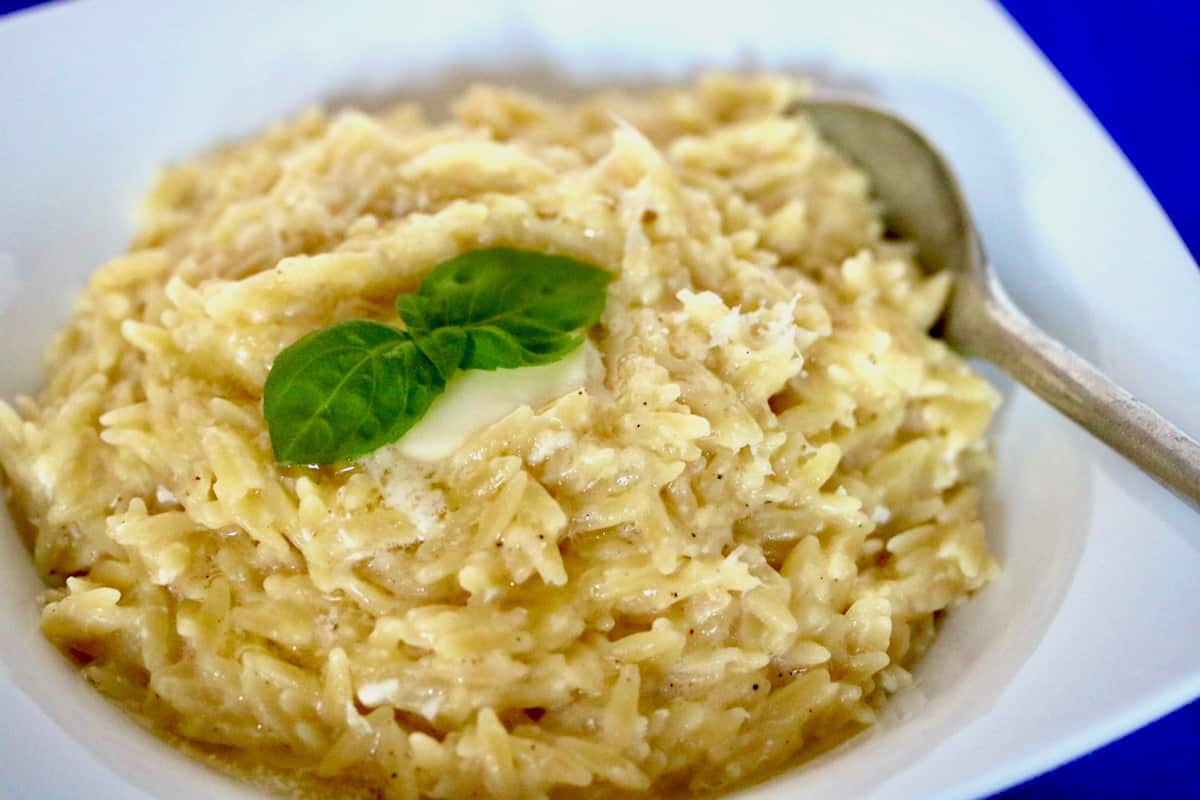 Bowl of pastina topped with butter and basil.