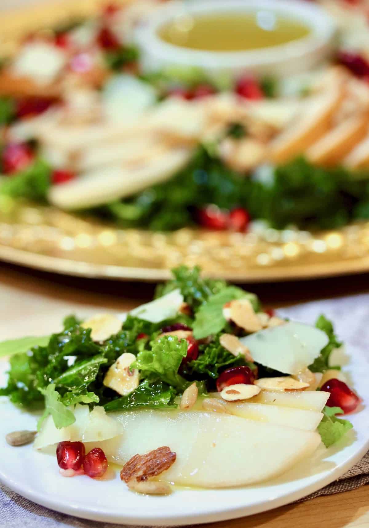 Pears, kale, pomegranate seeds, nuts salad plated.